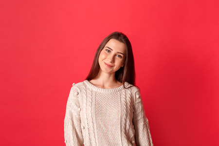 Freestyle. Young woman standing isolated on red smiling cuteの写真素材
