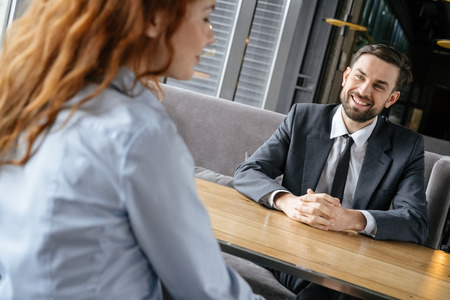 Businesspeople having business lunch at restaurant sitting man looking at woman smiling cheerfulの写真素材