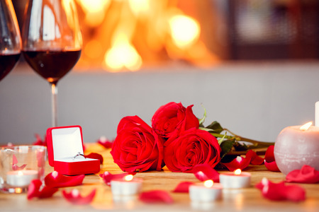 Date in restaurant decorated table with bouquet and ring in a box no people close-upの写真素材