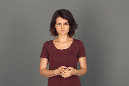 Freestyle. Young woman isolated on grey looking camera concerned