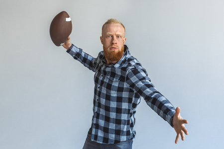 Freestyle. Mature man standing isolated on grey throwing ball motivatedの写真素材