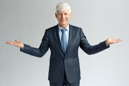 Business Lifestyle. Businessman standing isolated on gray hands aside smiling happyの写真素材