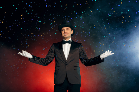 Professional Occupation. Showman in suit gloves and hat standing isolated on wall starting show smiling happyの写真素材