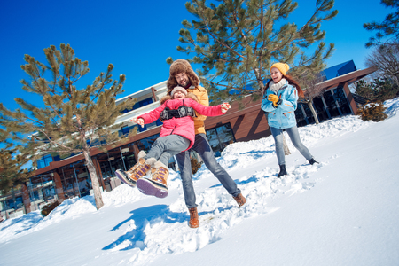 Winter vacation. Family time together outdoors man holding girl spinning laughing excitedの写真素材