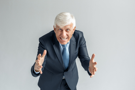 Business Lifestyle. Businessman standing isolated on gray gesturing to camera smiling toothy close-upの写真素材