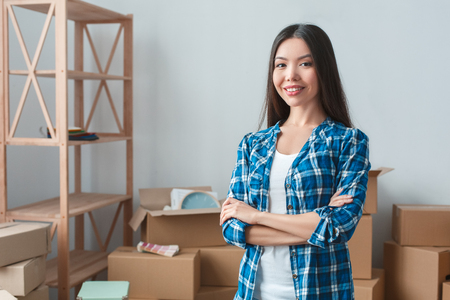 Young woman moving to a new place standing crossed arms smiling cheerfulの写真素材