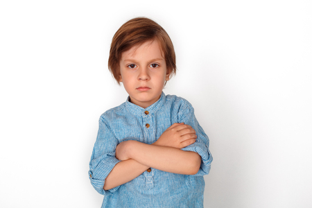 Boy studio standing isolated on grey vrossed arms angryの写真素材