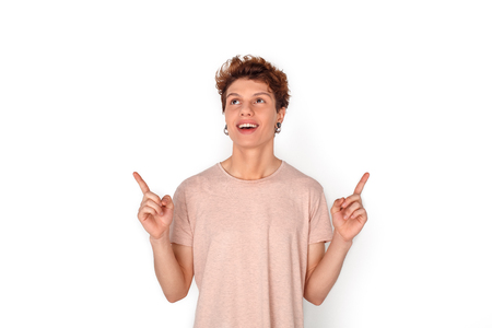 Teenager with earrings studio standing isolated on white pointing at space up excitedの写真素材