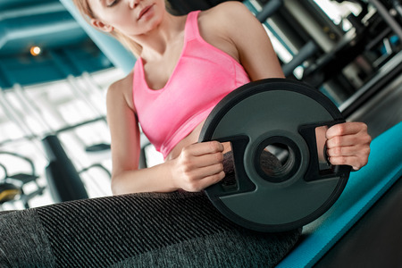Young girl in gym healthy lifestyle sitting on mat with plate close-upの写真素材