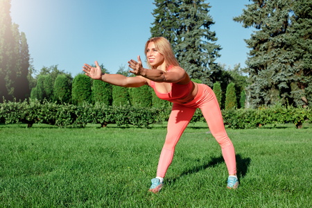 Healthy Lifestyle. Woman practicing yoga outdoors bending forward smiling motivatedの写真素材