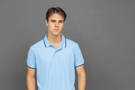 Freestyle. Teenager boy standing isolated on grey looking camera seriousの写真素材