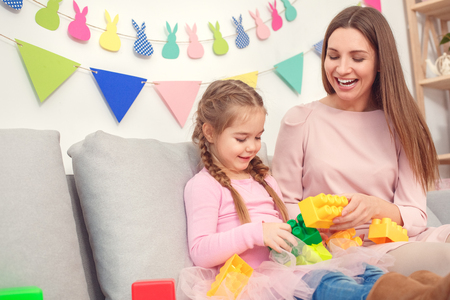 Mother and daughter together at home celebration concept playing toy building bricksの写真素材