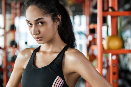 Young woman in gym sporty lifestyle standing close-up looking camera playfulの写真素材