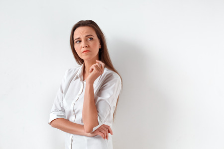 Freestyle. Woman standing isolated on white looking aside concernedの写真素材