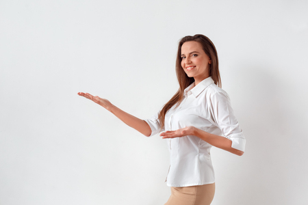 Freestyle. Woman standing isolated on white showing space aside smiling confidentの写真素材
