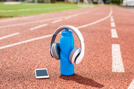 Objects on stadium track bottle of water smartphone and headphones close-upの写真素材
