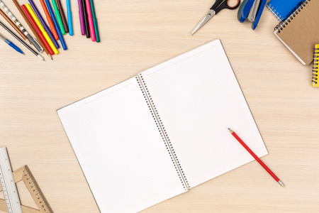 Wooden desk workplace top view nobody opened notebook and stationery to do list