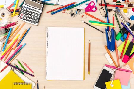 Wooden desk messed with stationery workplace top view nobody empty notebook and lead pencilの写真素材