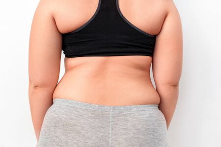 Young chubby woman standing isolated on white wall showing back close-upの写真素材