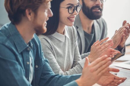 Startupers working together at office having business meeting clapping smiling cheerful close-up