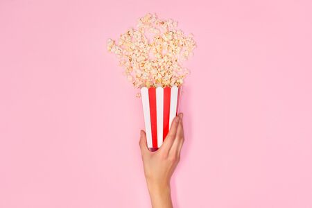 Persong holding box of popcorn isolated on pink close-up top viewの写真素材