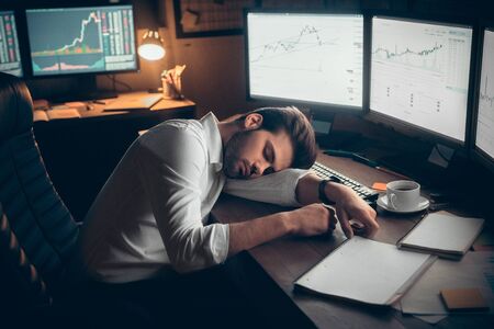 Young male trader at office work concept sitting sleeping.の写真素材