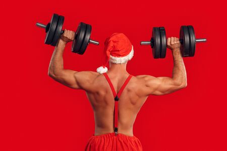 Nude Santa Claus training back with dumbbellの写真素材