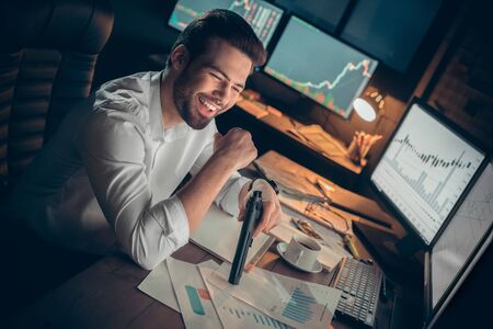 Young male trader at office work concept sitting with gun.の写真素材