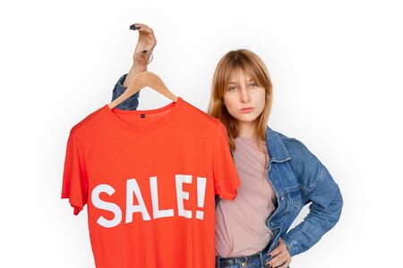 Black Friday. Young woman standing isolated on white holding t-shirt up sale sign posing to camera confidentの写真素材