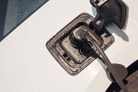 Elcetric car close-up at charging station isolated no people transportation charging with ev charger in water drops top viewの写真素材