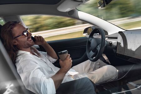 Mode of Transport. Bearded man with long hair in sunglasses traveling sitting inside electric car...