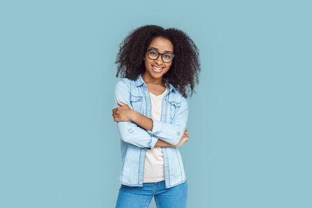 Freestyle. African girl wearing glasses standing isolated on gray crossed arms smiling joyfulの写真素材