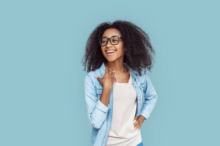 Freestyle. African girl wearing glasses standing isolated on gray laughing cheerfulの写真素材