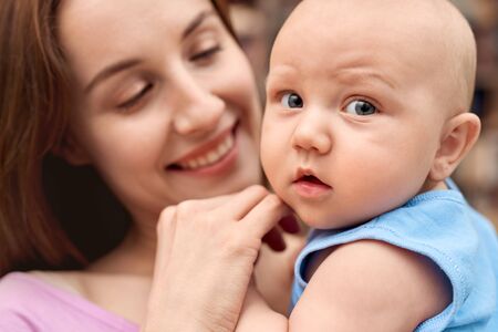 Young adult woman looking at her little newborn offspring