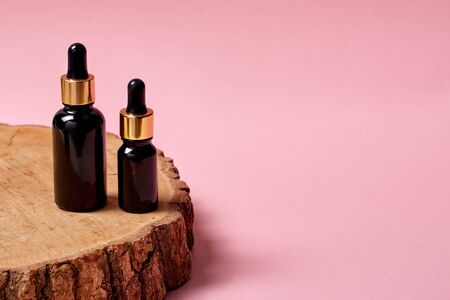 Anti-aging formula hyaluronic acid with collagen isolated on wood trunk on pink background close-up copy space for textの写真素材