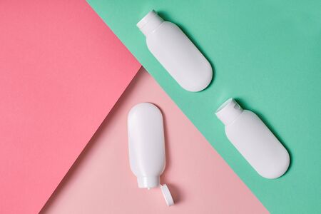 Concept of moisturizer and skin care. Top view of bottles with cosmetics products lying on pastel colorful backgroundの写真素材