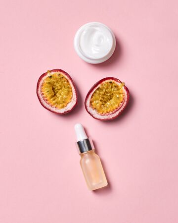 Hyaluronic acid cream in jar and halved passion fruit isolated on pink background beauty careの写真素材