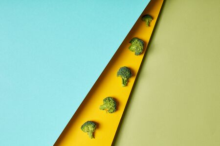 Broccoli isolated on yellow green and blue background copy space for text or product dedcor conceptの写真素材