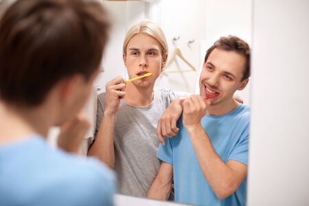 Homosexual and same sex couple brushing teeth togetherの写真素材