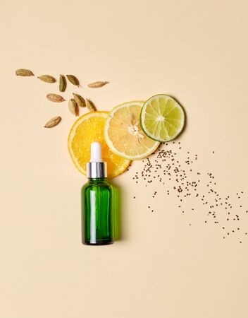 Concept of natural beauty products. Flat lay of serum oil with pipette and citrus vitamin component and fresh ingredients on pastel backgroundの写真素材