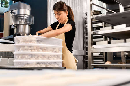 Professional chef unpack raw dough from plastic containerの写真素材