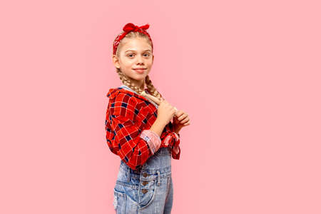 Teenager girl looking at camera, standing in studioの写真素材