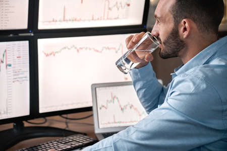 Stock broker drinking water, analyzing global bitcoin price