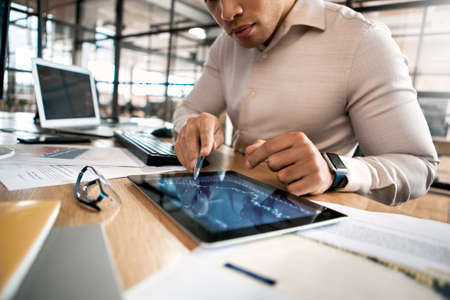 Businessman analyzing stat and dynamic on forex charts at tablet computerの写真素材