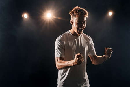 Young adult athlete screaming and holding victory fistsの写真素材