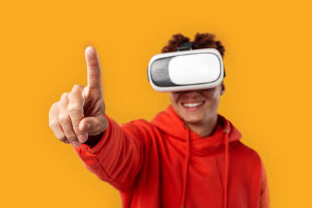 Young adult mulatto in vr glasses pointing with fingerの写真素材