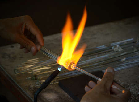 Local worker is working on glass for handicraft product.