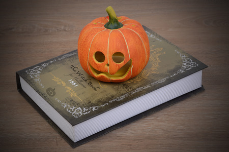 Halloween pumpkin and witch book for halloween night on the table.の写真素材