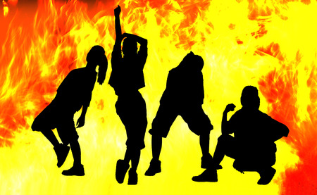 Shadow of four girls dancing in fire background.の写真素材