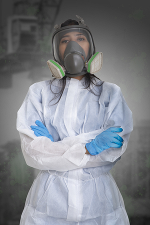 Female worker in dust protection suit standing with her arm crossed.